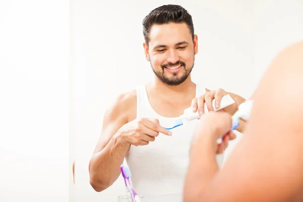 Mann gießt Zahnpasta ein — Stockfoto