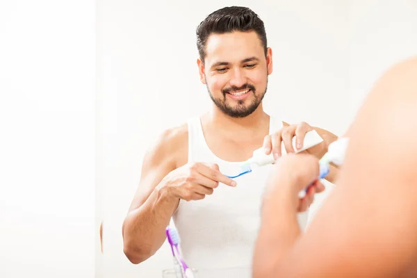 Hombre vertiendo un poco de pasta de dientes — Foto de Stock