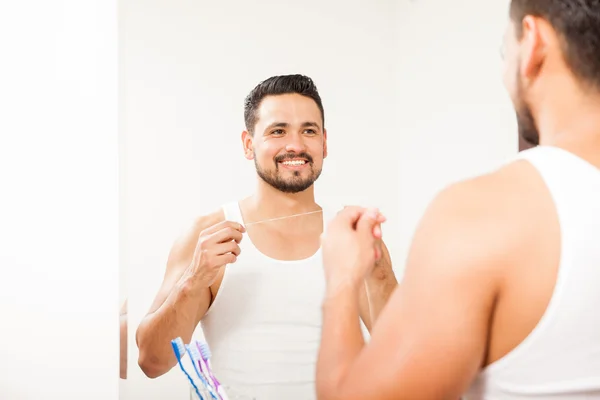 Young Hispanic man flossing — Stock Photo, Image