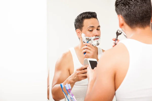 Man multitasking and shaving — Stock Photo, Image