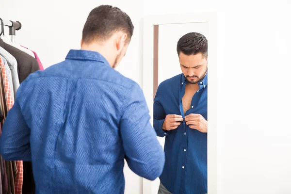 Mann zieht blaues Hemd an — Stockfoto