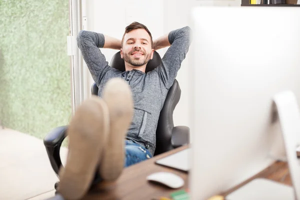 Mladý muž relaxační ve své kanceláři — Stock fotografie