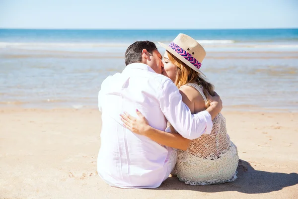 Pareja sentada en la arena —  Fotos de Stock