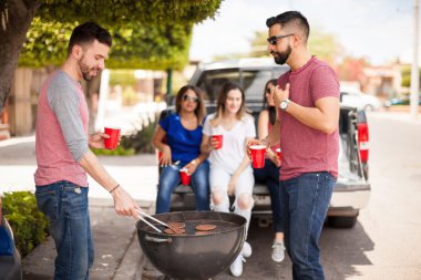 Erkek arkadaşlar açık havada hamburger ızgara