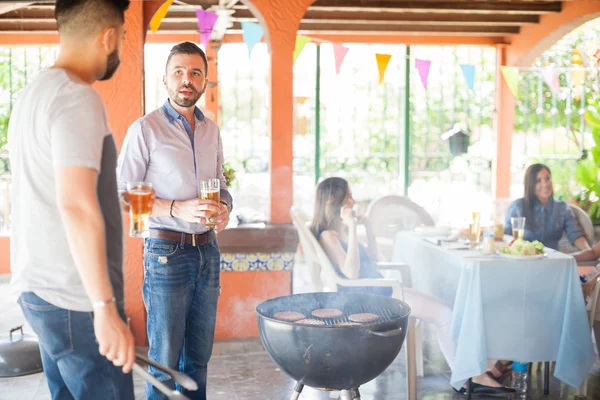 Male friends making burgers in a grill — Stock Photo, Image