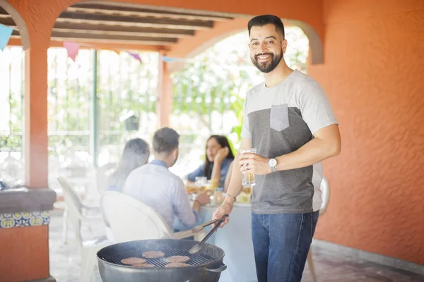 Hambúrgueres de cozinha masculinos em uma grade ao ar livre — Fotografia de Stock
