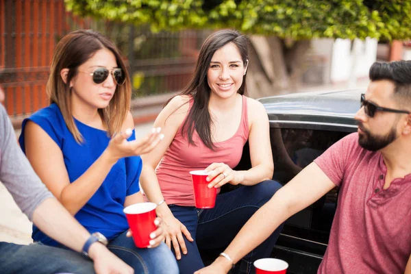 Cute young female drinking with her friends — Stock Photo, Image