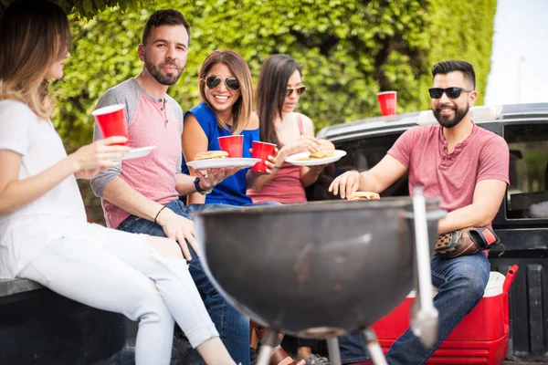 Personas comiendo hamburguesas al lado de una parrilla —  Fotos de Stock