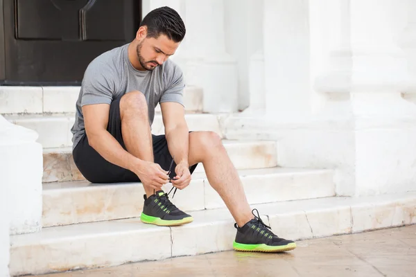 Mann mit Bart bindet sich die Schuhe — Stockfoto