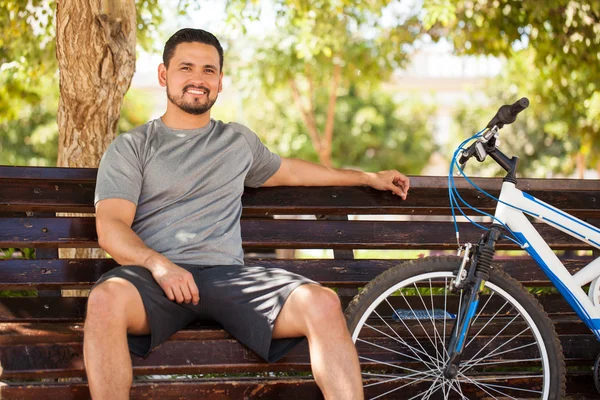 Radfahrer ruht sich auf Parkbank aus — Stockfoto