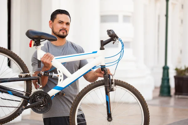 Mann in sportlichem Outfit hebt Fahrrad — Stockfoto