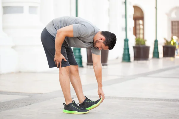 Hombre estirando y tocando sus dedos de los pies — Foto de Stock