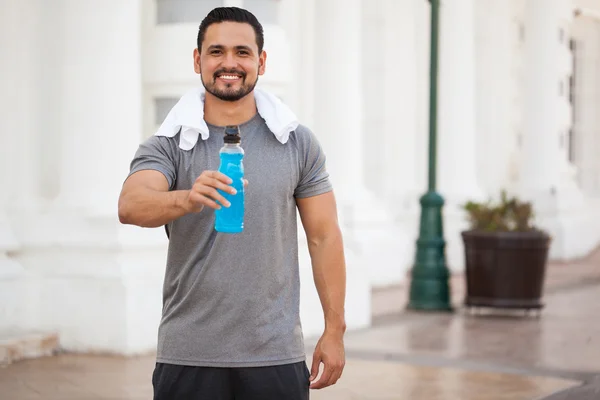 Mężczyzna trzyma butelkę napój sportowy — Zdjęcie stockowe