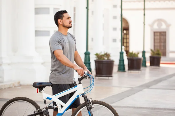 Чоловік стоїть поруч зі своїм велосипедом — стокове фото