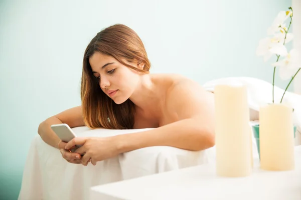 Brunette gebruikend een smartphone — Stockfoto