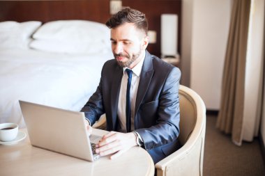 bir dizüstü bilgisayar üzerinde çalışan iş adamı 