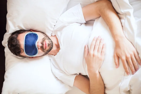 Uomo che indossa una maschera del sonno — Foto Stock