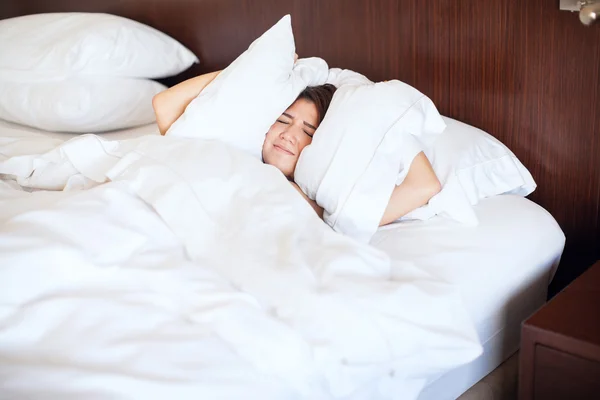 Die betrekking hebben op haar oren met een kussens — Stockfoto