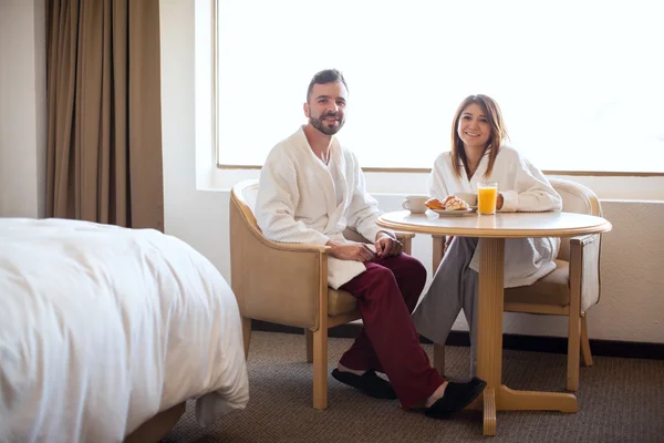 Casal vestindo roupões e tomando café da manhã — Fotografia de Stock