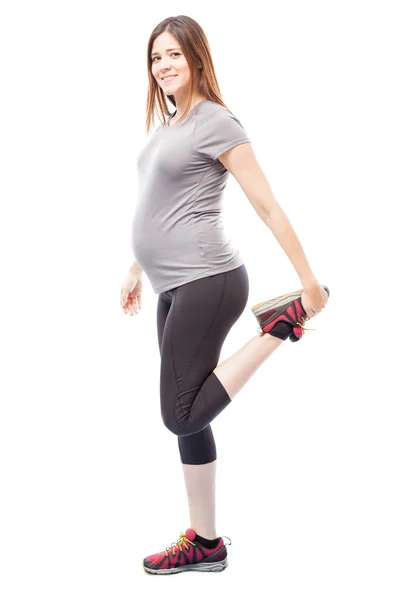 Gravid kvinna stretching hennes ben — Stockfoto