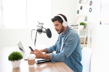 Bir blog yazarı ve radyo sunucusunun profil görüntüsü akıllı telefonuna bakıyor ve hayranları ve seyircilerinin sorularını okuyor.