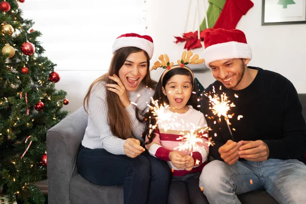 家でクリスマスを祝いながら キラキラと楽しい3人の家族が驚いています — ストック写真