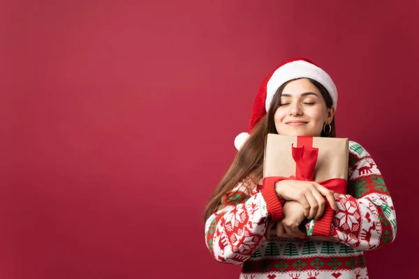 Schöne Lateinerin Umarmt Weihnachtsgeschenk Mit Geschlossenen Augen Und Viel Kopierraum — Stockfoto