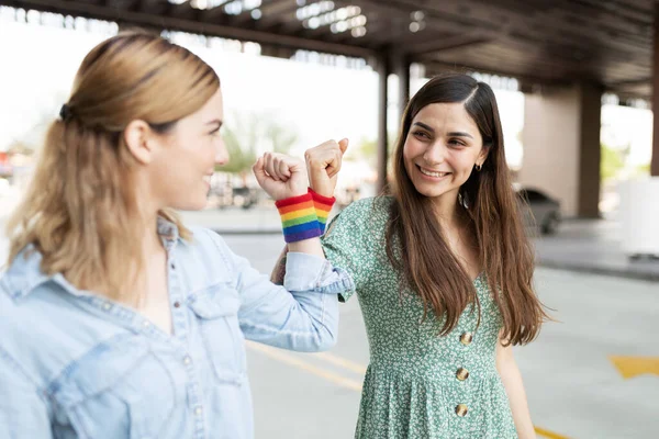 Две Молодые Женщины Геи Лицом Лицу Собирают Свои Браслеты Радужными — стоковое фото