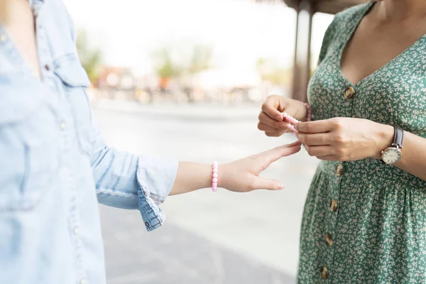 閉じるアップの若いです女性与えます彼女の女性友人Aマッチング友情ピンクブレスレット — ストック写真