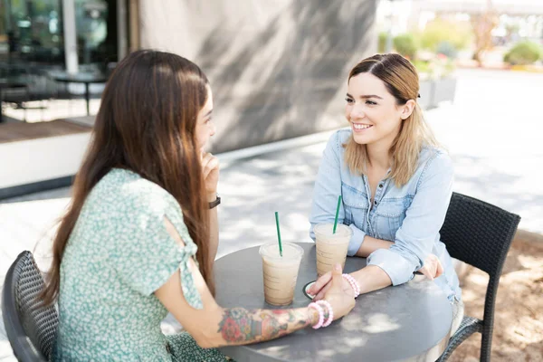 コーヒーショップで手を取り合いながら顔をしかめっ面の若い女性 — ストック写真