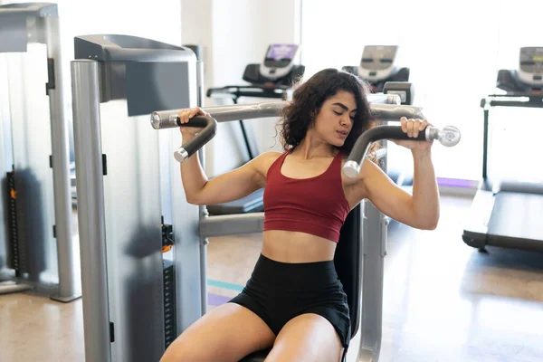 Attraktive Frau Beim Betrachten Ihrer Muskeln Einem Sitzenden Schulterpressgerät Fitnessclub — Stockfoto
