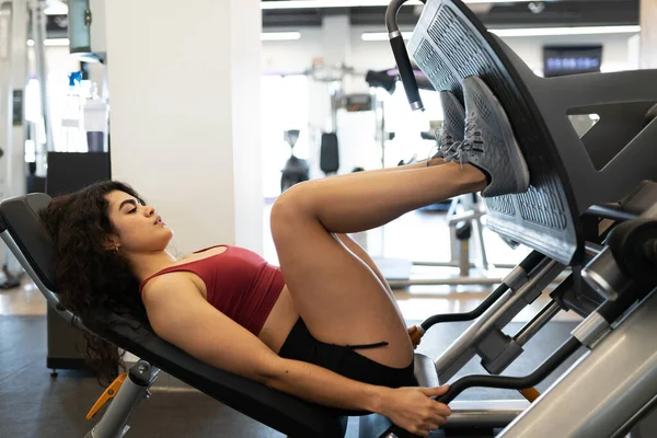 Spor Salonunda Bacak Presi Makinesiyle Kaslarını Çalıştıran Zinde Bir Kadının — Stok fotoğraf