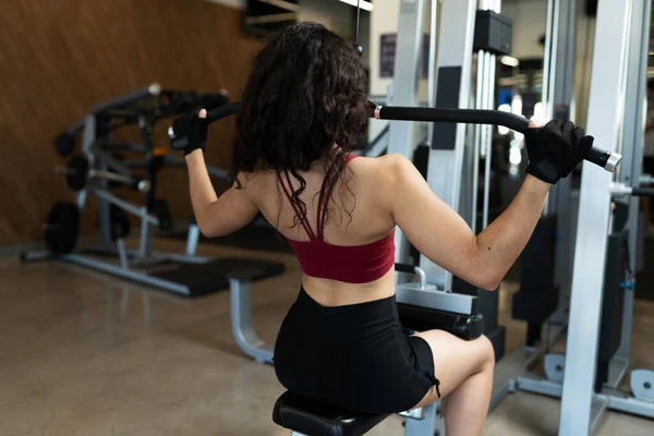 Rear View Latin Woman Curly Hair Strenghtening Her Back Machine — Stock Photo, Image