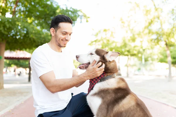 Tatlı Spanyol Adam Mutlu Görünüyor Köpeğinin Kafasını Parkta Okşuyor — Stok fotoğraf