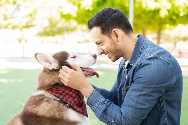 Çekici Yetişkin Bir Adam Parkta Gülümseyip Köpeğinin Kafasını Okşuyor — Stok fotoğraf