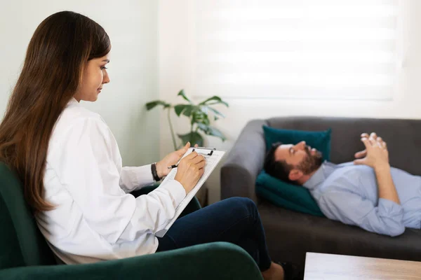 Jonge Vrouwelijke Pshycoloog Schrijft Haar Kaart Tijdens Een Therapiesessie Met — Stockfoto