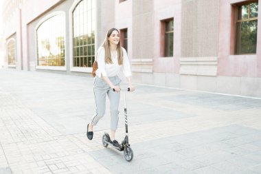 30 'lu yaşlarda mutlu bir kadın işçi. Şehirdeki iş yerine gitmek için çevre dostu bir araç kullanıyor.