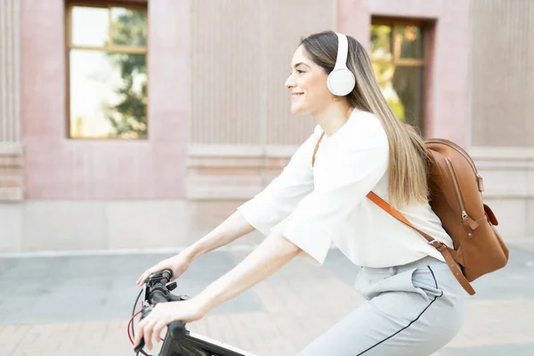 Trabalhadora Feliz Ativa Com Fones Ouvido Uma Mochila Andando Bicicleta — Fotografia de Stock