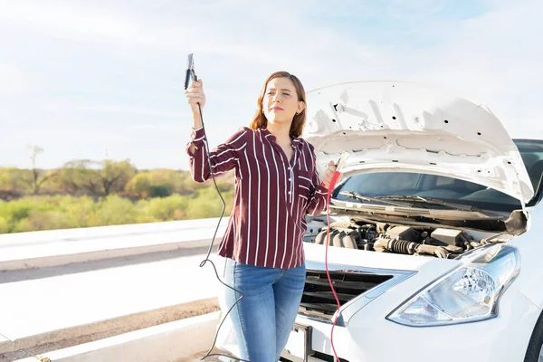 20多岁的妇女试图从路过的司机那里得到帮助 以便在公路旁边发动她的汽车电池 — 图库照片
