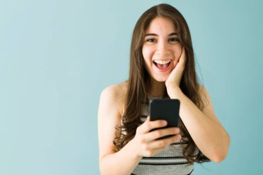 20 'li yaşlardaki güzel bir kadın mutlu çünkü akıllı telefonundaki bir mesajla iyi haberler aldı. 