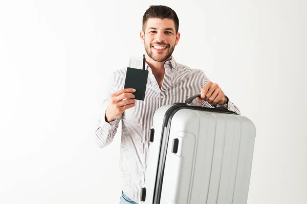 空港に行く準備ができている彼の20代の笑顔の男の肖像とスーツケース 飛行機のチケットとパスポートを運ぶ — ストック写真