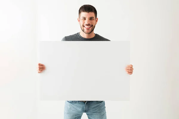 Retrato Joven Hispano Sonriendo Luciendo Feliz Mientras Sostiene Letrero Blanco —  Fotos de Stock