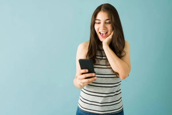 Студийный Снимок Счастливой Молодой Женщины Смотрящей Смс Смартфоне Удивленным Шокированным — стоковое фото