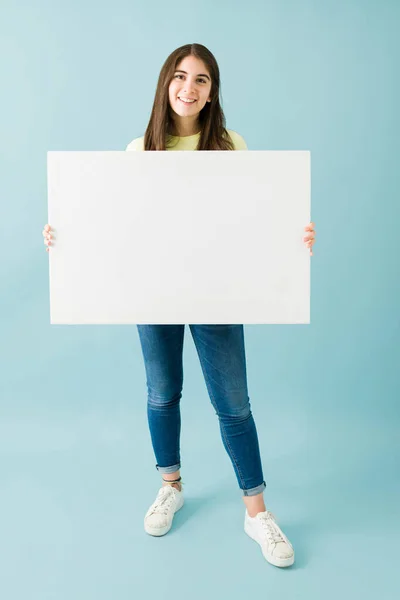 Mujer Joven Caucásica Sonriendo Mirando Feliz Mientras Sostiene Signo Blanco —  Fotos de Stock