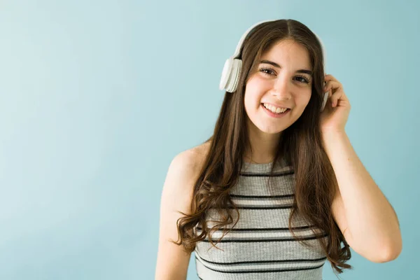 ヘッドフォンで音楽を聴き カメラに微笑む美しい若い白人女性 — ストック写真