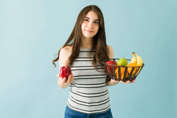 一个对营养感兴趣的年轻女人的画像是拿着一篮子苹果 橙子和梨的水果 — 图库照片