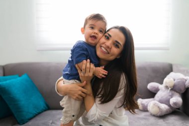 Güzel, gülümseyen bir annenin portresi ve oğlu kanepede oturuyor.