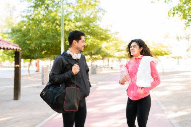 Yakışıklı genç bir adam ve aktif giysili güzel bir kadın flört ediyor ve gülümsüyor. Formda çiftler parktaki antrenmanlarını bitirdikten sonra çok mutlu oluyorlar.