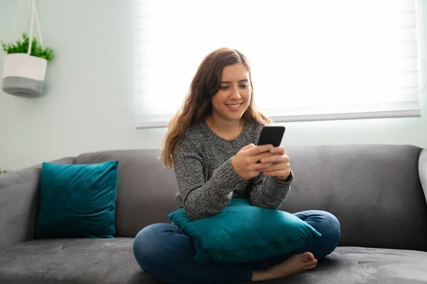 Wanita Tampan Berusia Tersenyum Dan Sms Ponsel Pintarnya Sambil Bersantai — Stok Foto