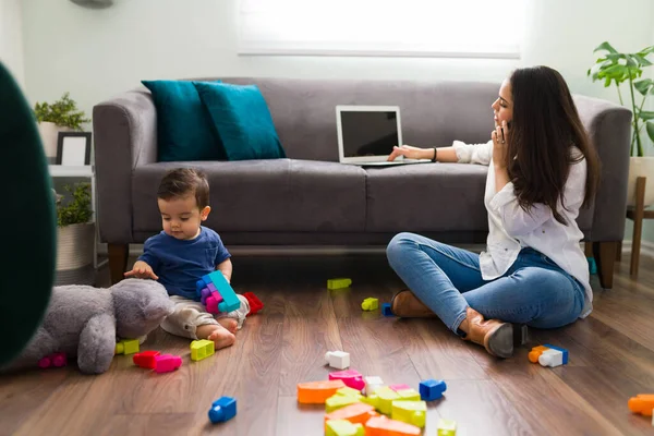 Joven Madre Hablando Por Teléfono Trabajando Portátil Mientras Bebé Juega — Foto de Stock